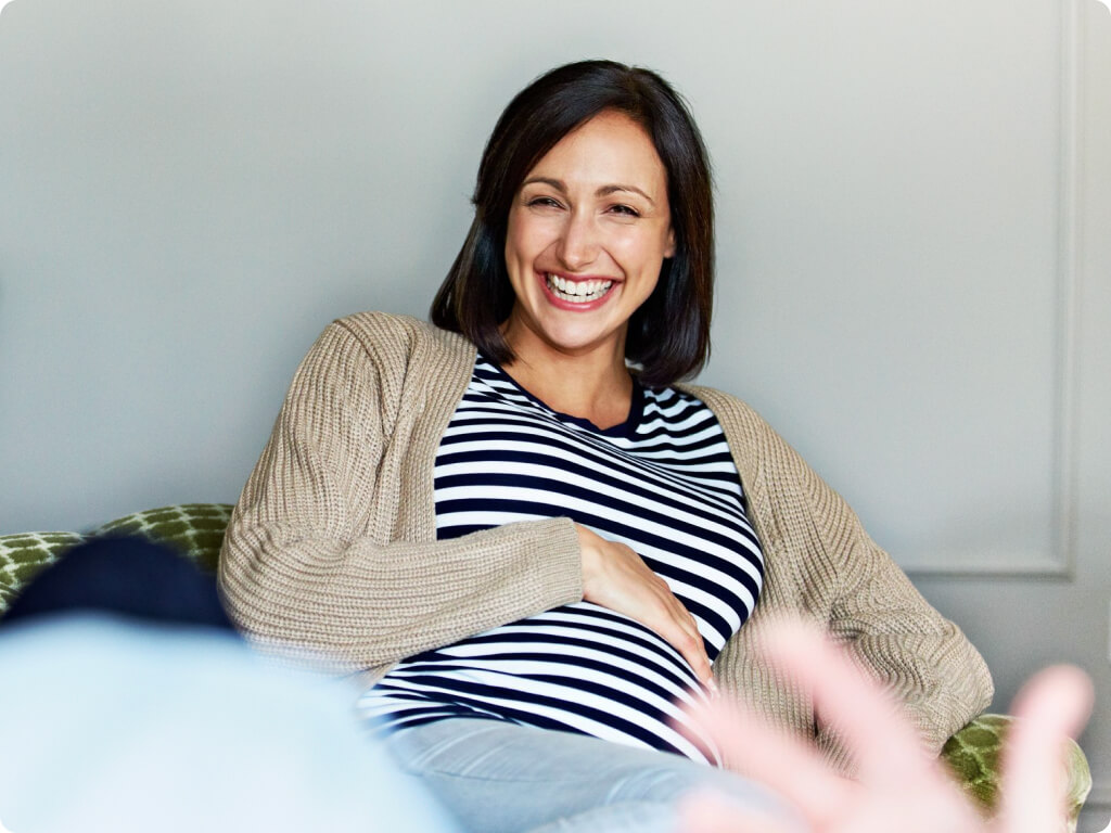Pregnant woman smiling on the sofa