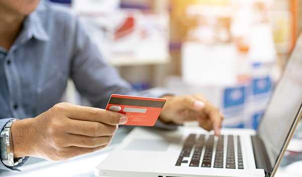 Person with credit card at laptop