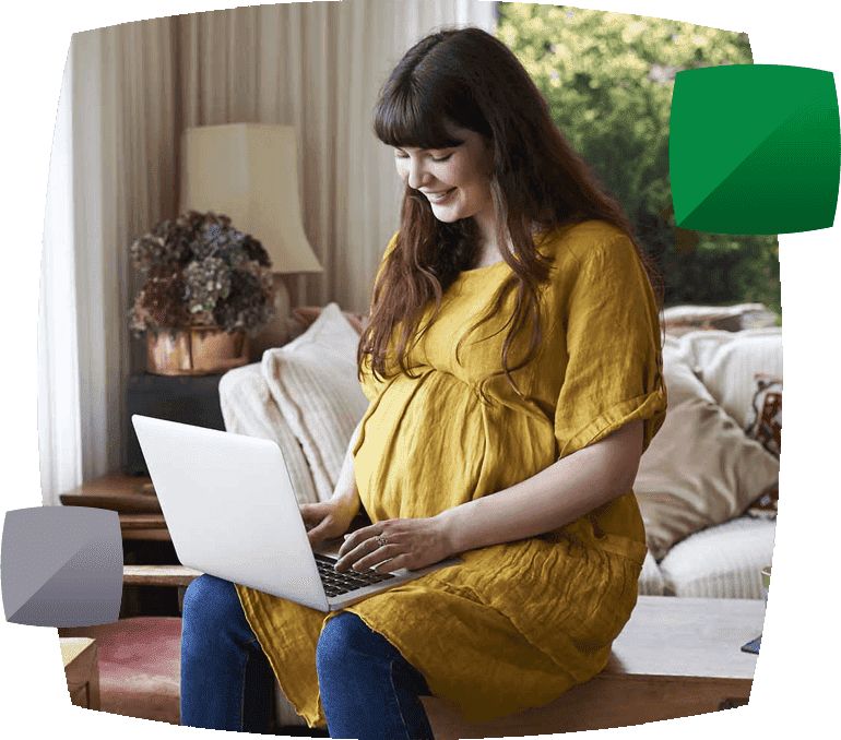 smiling pregnant woman on laptop