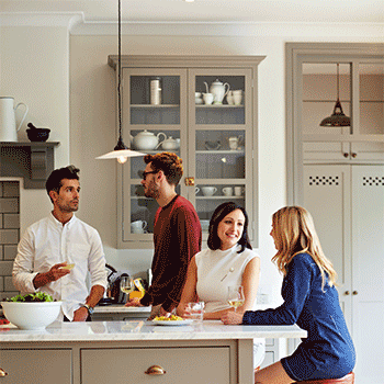 Four friends drinking in a kitchen
