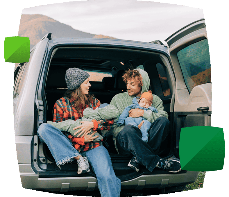 Young family sitting at the back of a car
