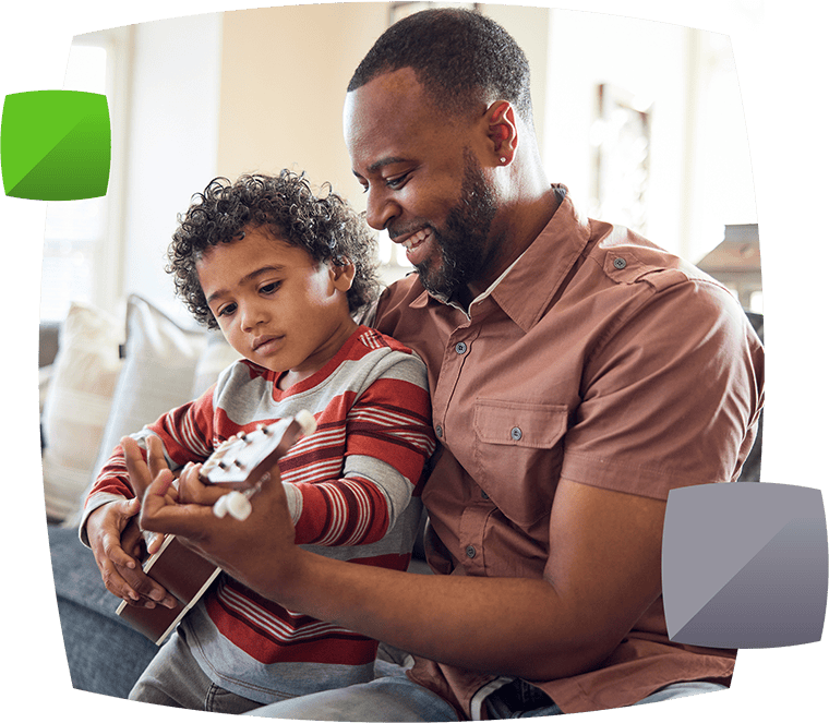 Father helping teach son to play the guitar